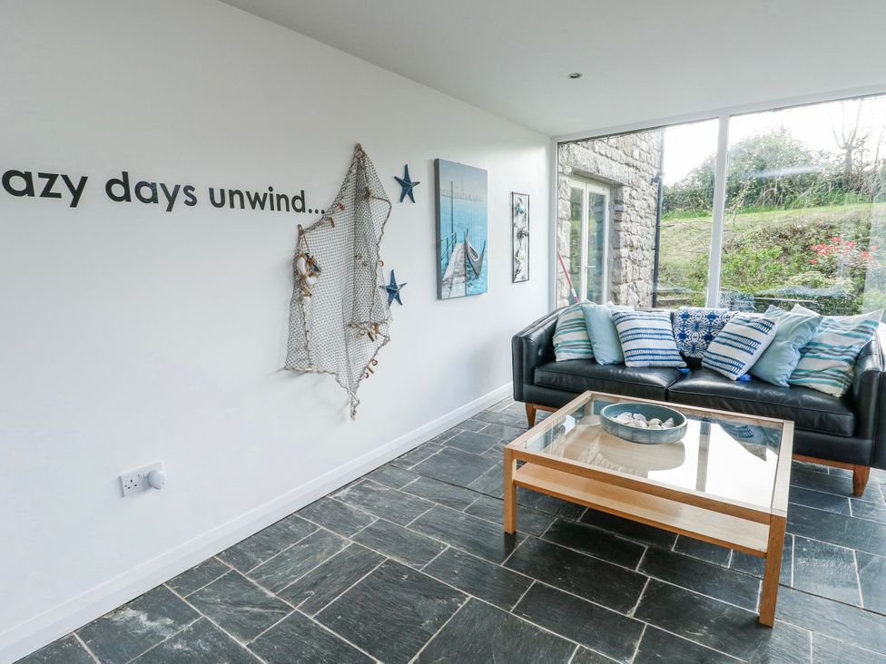 A snug with a sofa and coffee table at Too Hoots in Lligwy