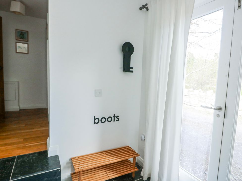 An entryway with a bench and a door at Too Hoots in Lligwy