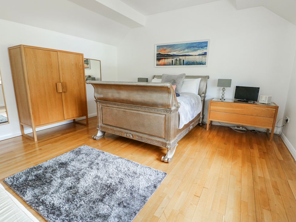 A bedroom with a bed and bedside table at Too Hoots in Lligwy