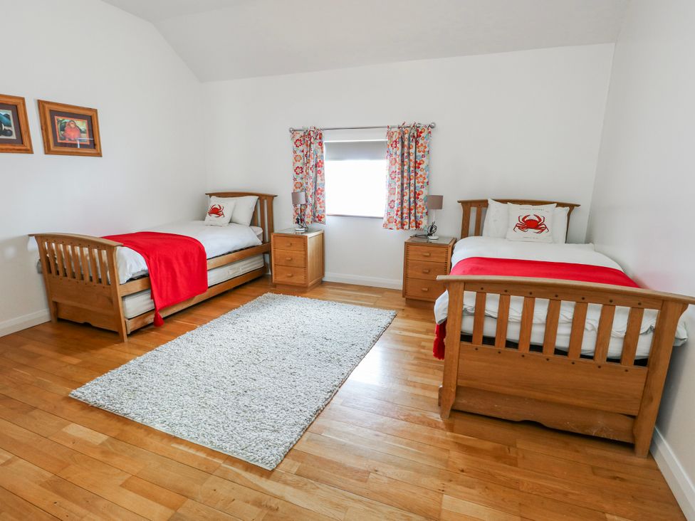 A bedroom with two beds and a window at Too Hoots in Lligwy