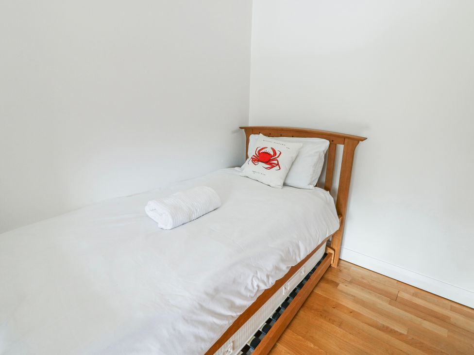 A bedroom with a single bed and a pillow at Too Hoots in Lligwy