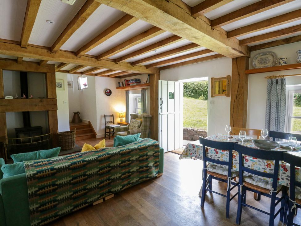 A living room with a sofa and dining area at Cynefin in Newport, Pembrokeshire