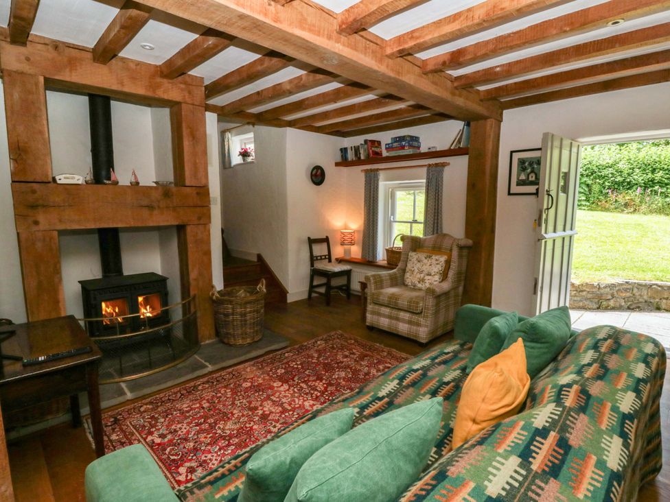 A living room with a fireplace and sofa at Cynefin, Newport, Pembrokeshire
