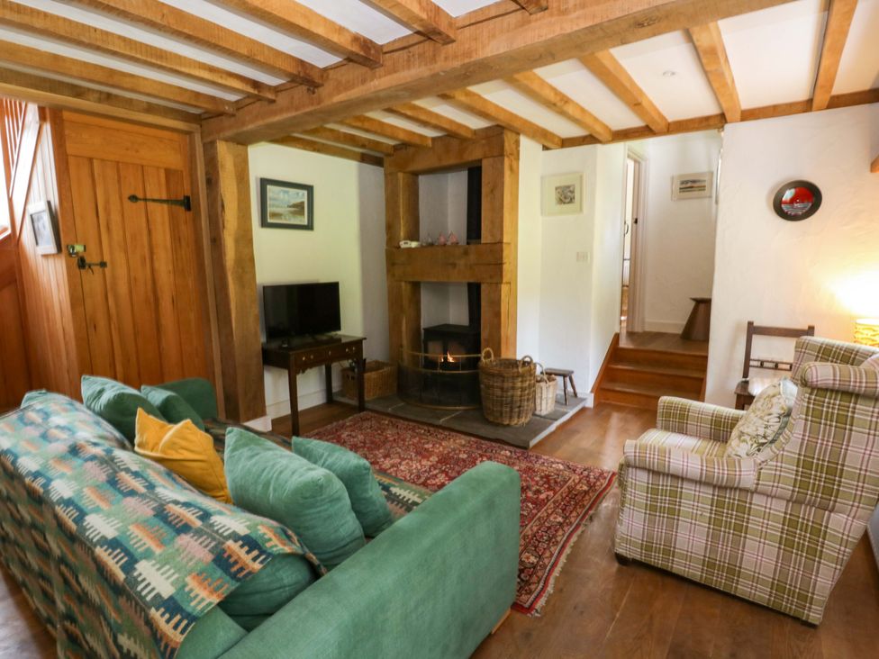 A living room with a sofa and fireplace at Cynefin in Newport, Pembrokeshire