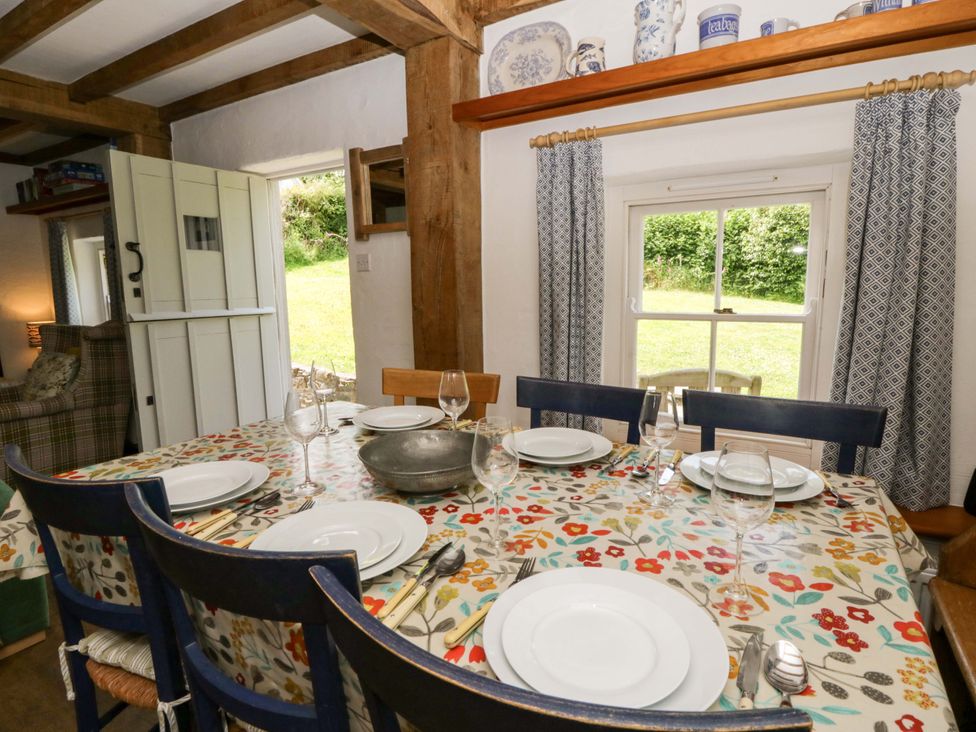 A dining room with a table set for dinner at Cynefin in Newport, Pembrokeshire