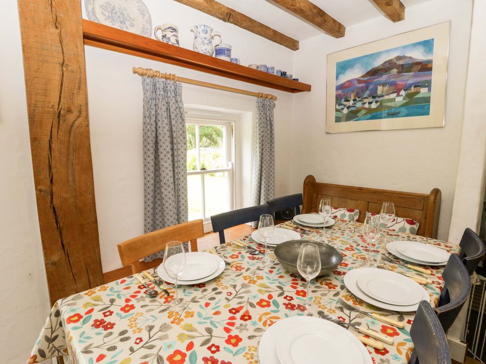 A dining room with a table set for meals at Cynefin in Newport, Pembrokeshire
