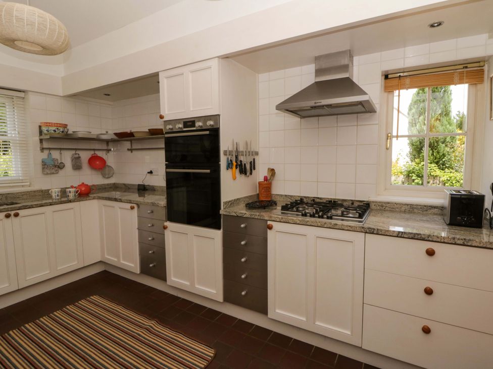 A kitchen with cabinets, stove, and countertop at Cynefin in Newport, Pembrokeshire