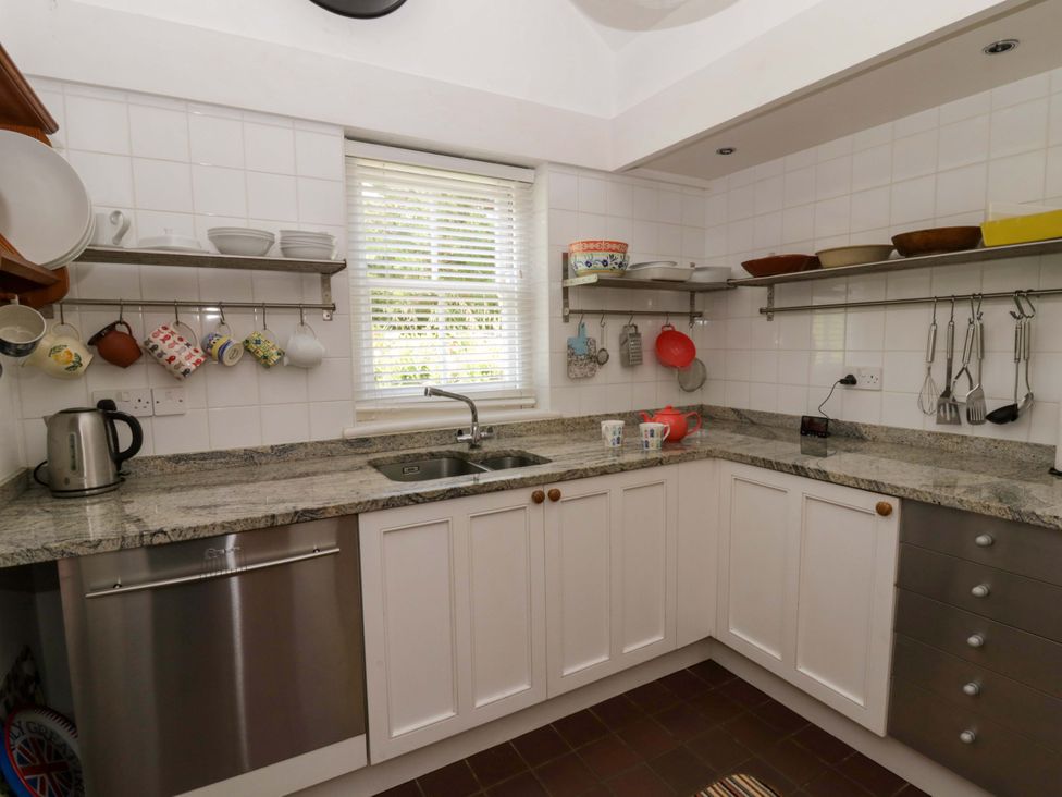 A kitchen with sink and shelves at Cynefin in Newport, Pembrokeshire