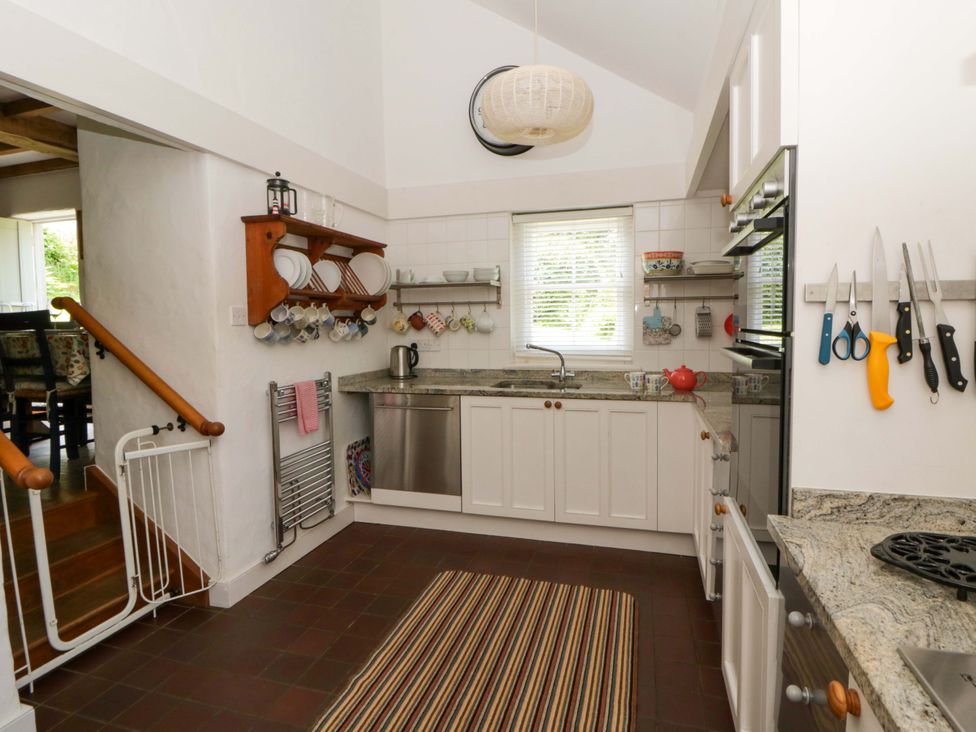 A kitchen with a sink and stove at Cynefin in Newport, Pembrokeshire
