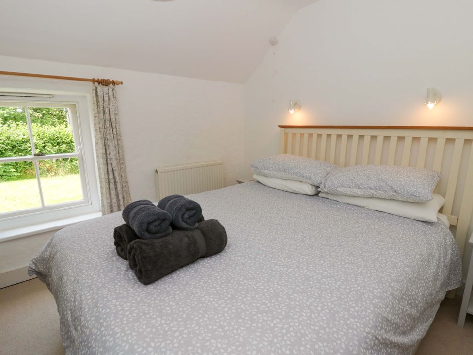 A bedroom with a bed and towels at Cynefin in Newport, Pembrokeshire