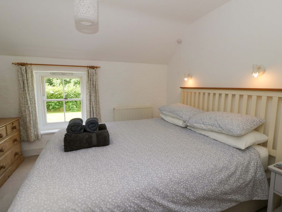 A bedroom with a bed and window at Cynefin in Newport, Pembrokeshire