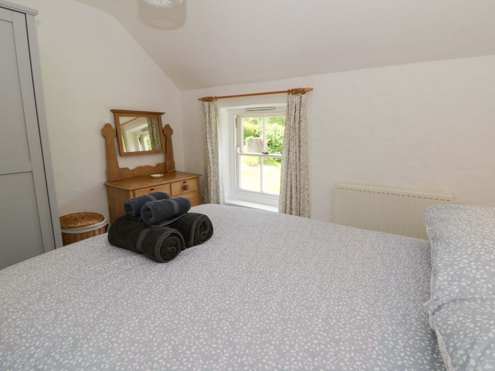 A bedroom with a bed and a dresser at Cynefin in Newport, Pembrokeshire