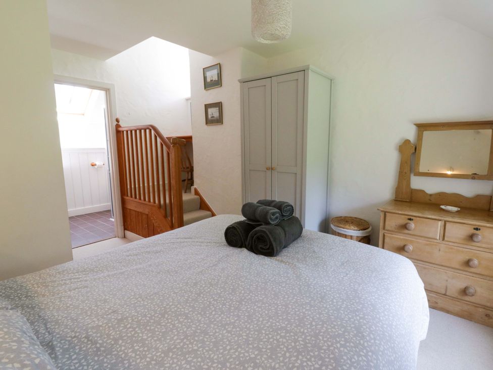 A bedroom with towels on the bed and a dressing table at Cynefin in Newport, Pembrokeshire
