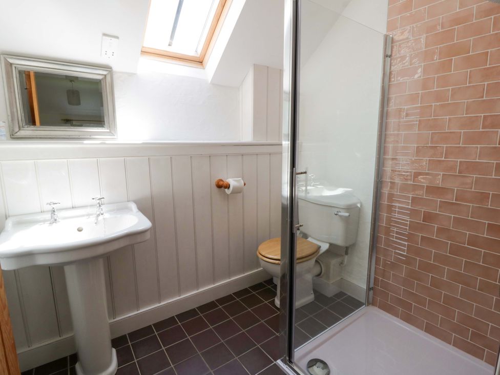 A bathroom with a sink, toilet, and shower at Cynefin, Newport, Pembrokeshire