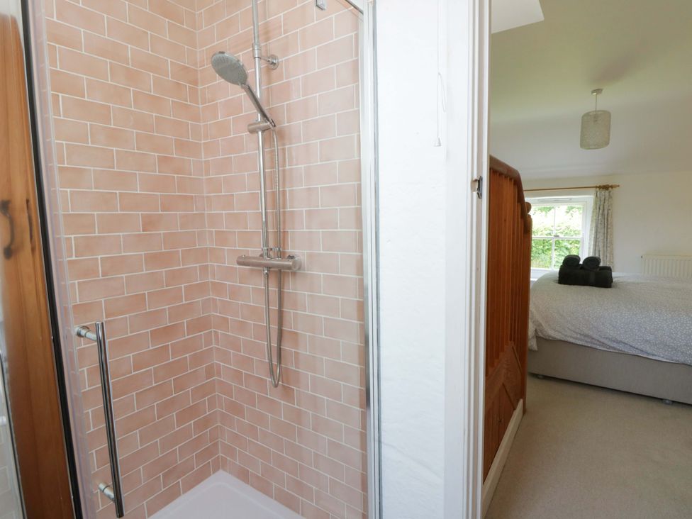 A shower area with tiled wall at Cynefin in Newport, Pembrokeshire