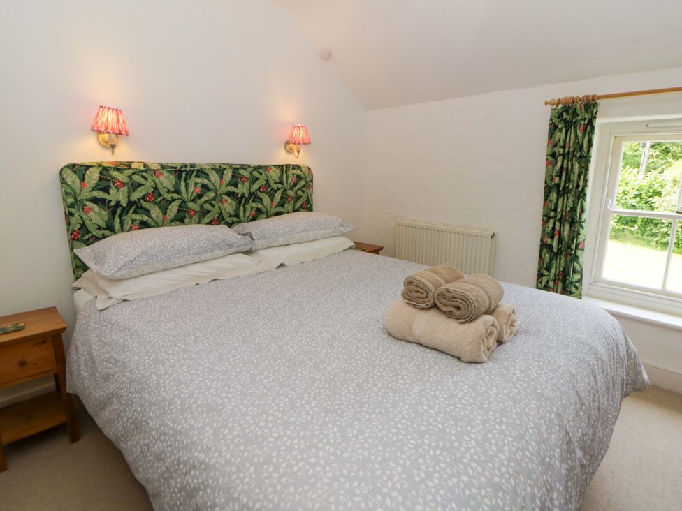 A bedroom with a bed and towels at Cynefin in Newport, Pembrokeshire