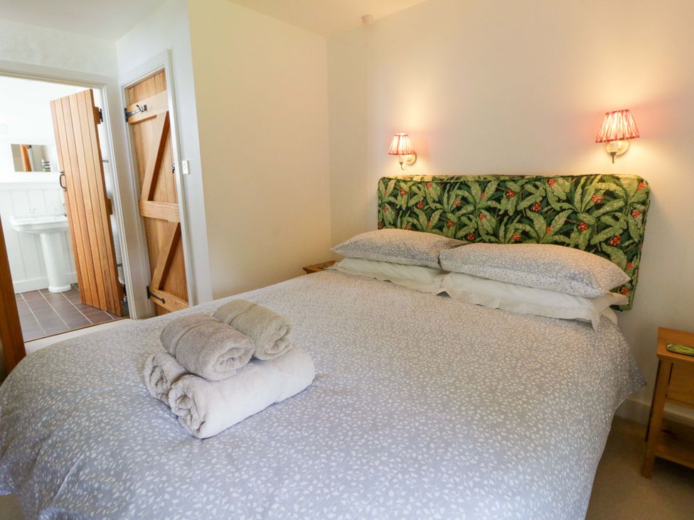 A bedroom with a bed and towels on it at Cynefin Newport, Pembrokeshire