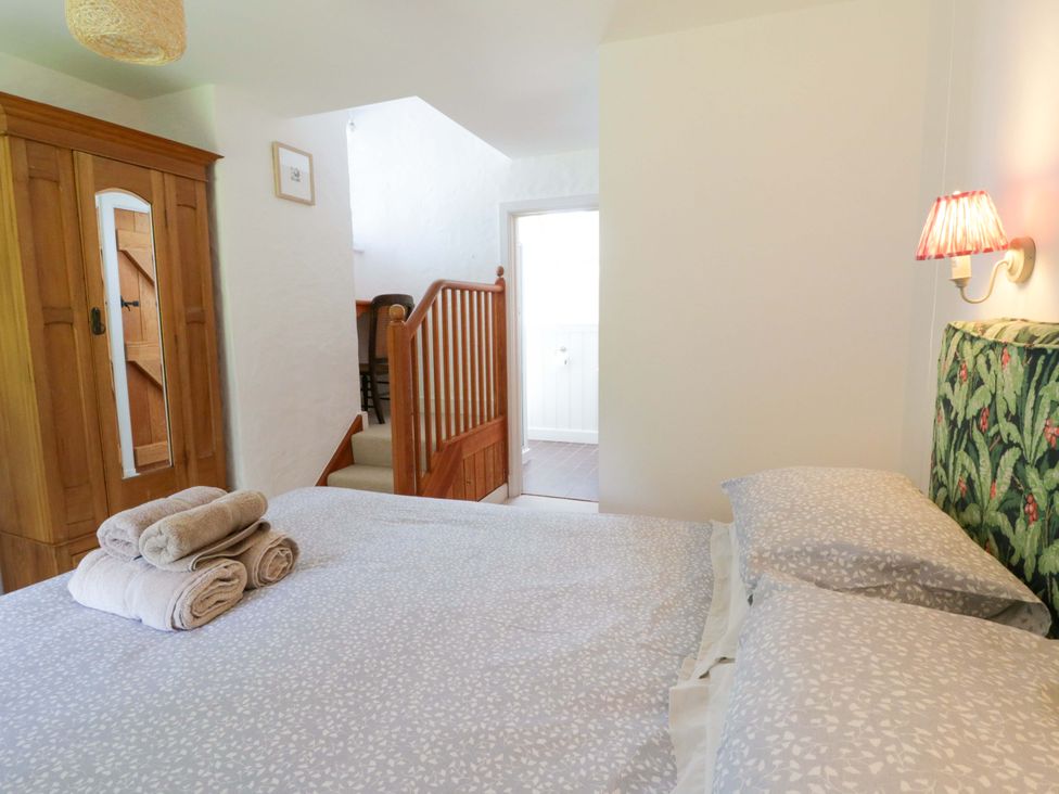 A bedroom with a bed and wardrobe at Cynefin in Newport, Pembrokeshire