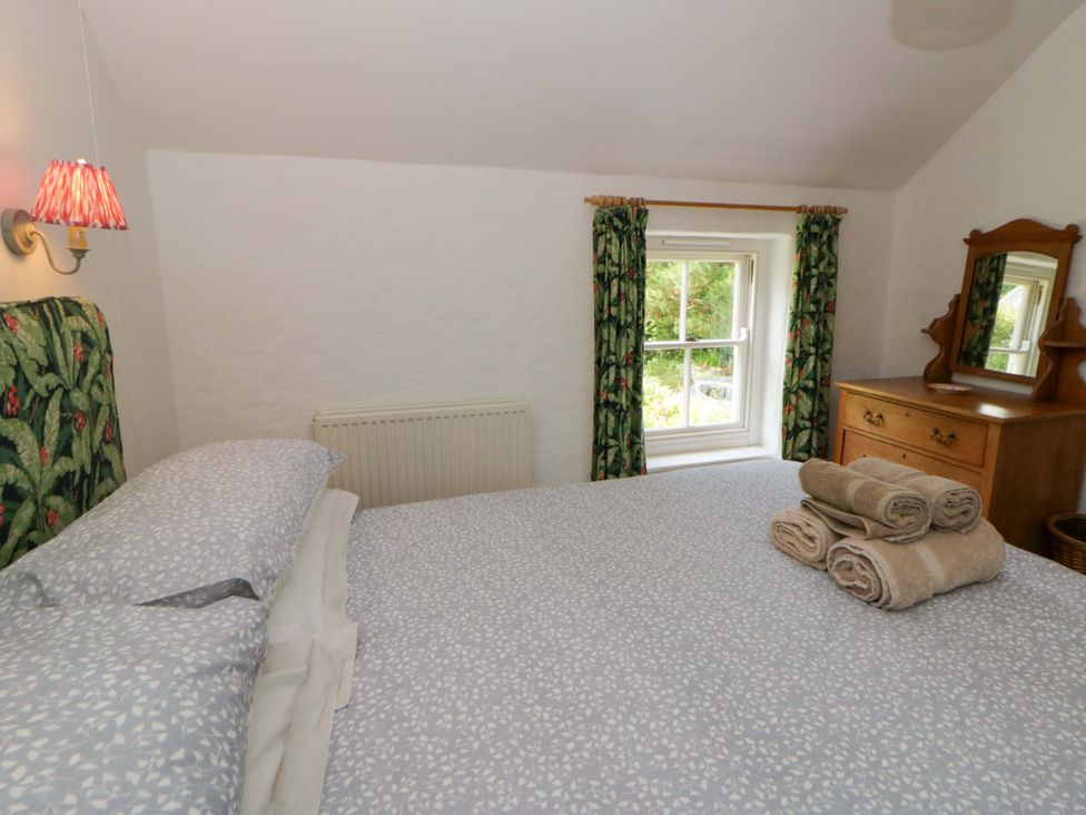 A bedroom with bed and dressing table at Cynefin in Newport, Pembrokeshire