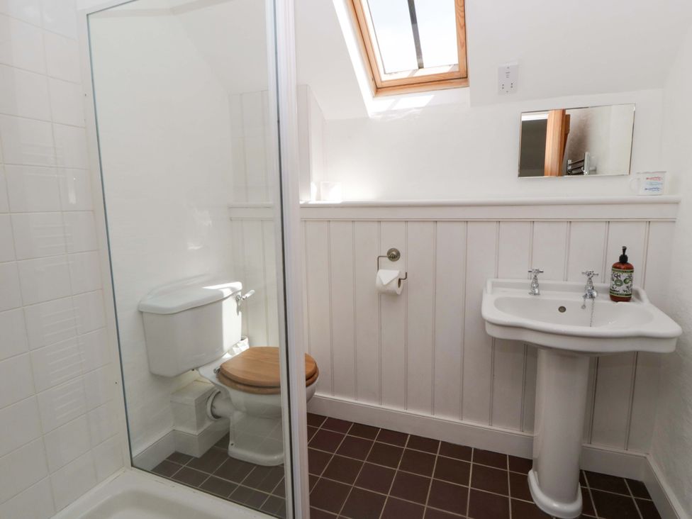 A bathroom with a shower, toilet, and sink at Cynefin in Newport, Pembrokeshire