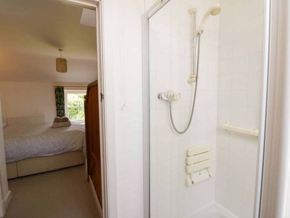 A bathroom with a shower and access to a bedroom at Cynefin Newport, Pembrokeshire