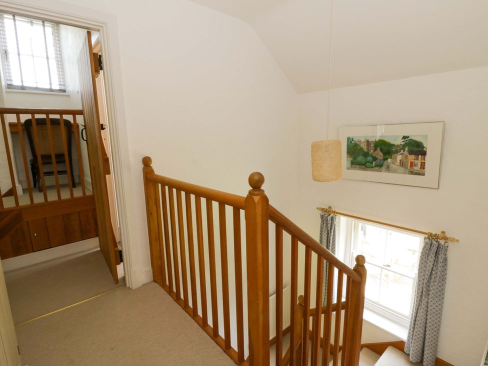 A hallway with a staircase and window at Cynefin in Newport, Pembrokeshire