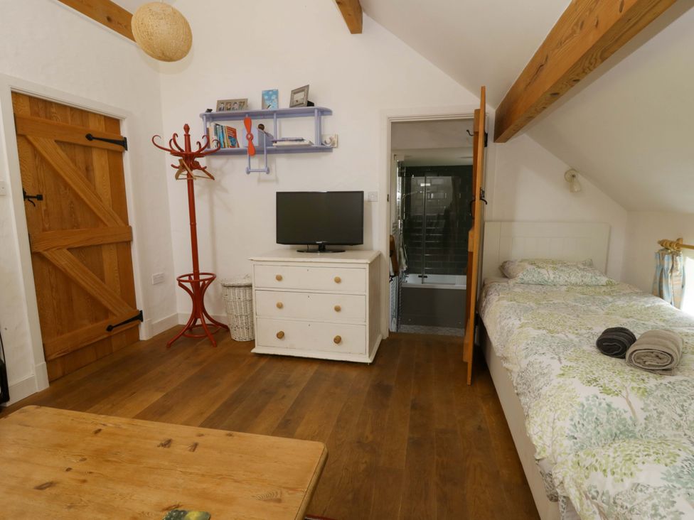 A bedroom with a bed and television at Cynefin in Newport, Pembrokeshire