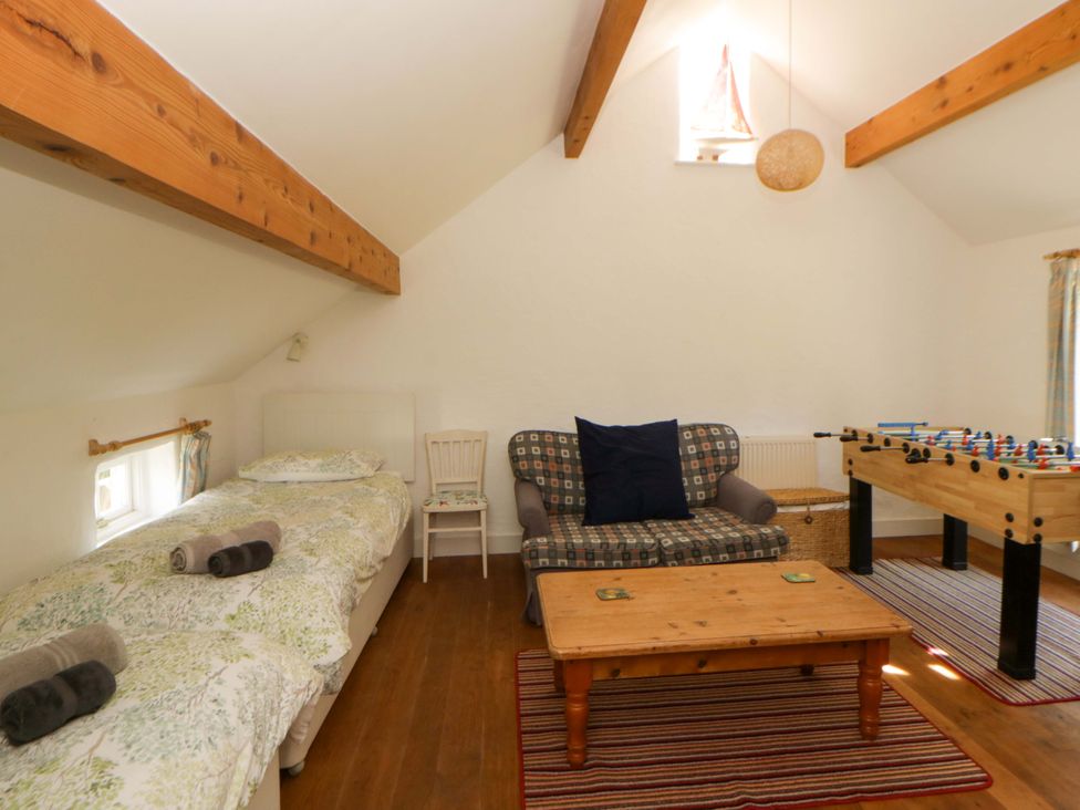 A bedroom with a bed and foosball table at Cynefin Newport, Pembrokeshire