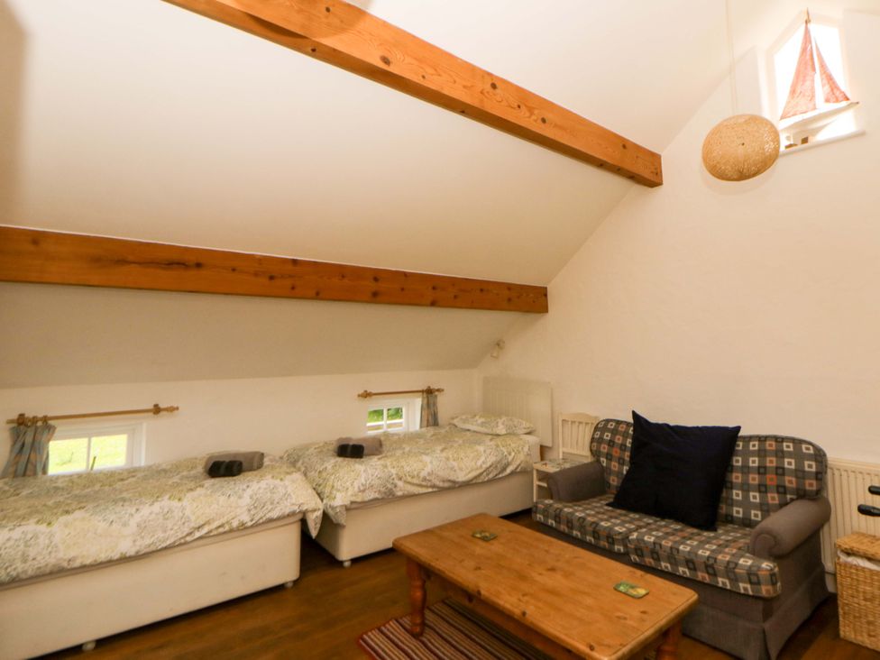A bedroom with two beds and a couch at Cynefin, Newport, Pembrokeshire