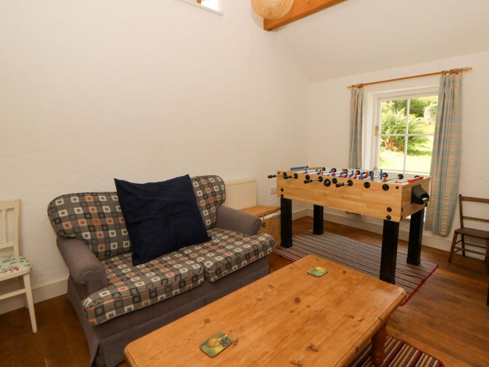 A snug with a foosball table and a sofa at Cynefin in Newport, Pembrokeshire
