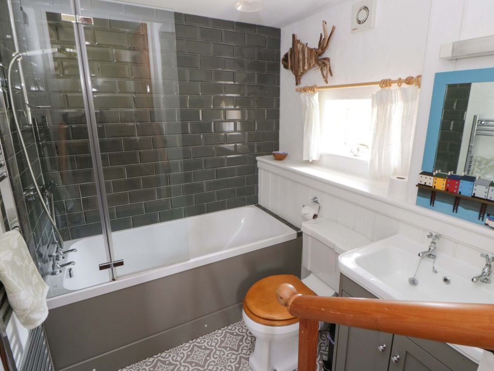 A bathroom with a shower and bathtub at Cynefin in Newport, Pembrokeshire