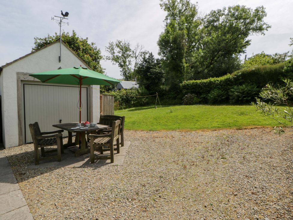 A garden area with a table and chairs at Cynefin in Newport, Pembrokeshire
