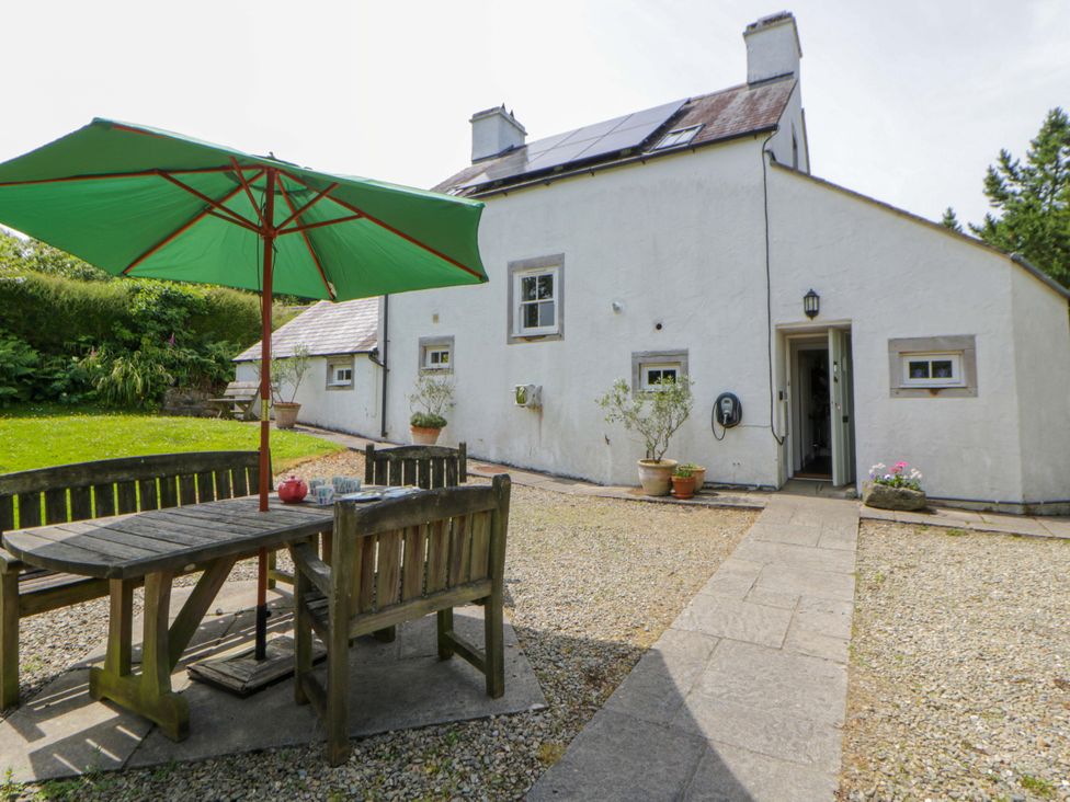 A garden with a table and chairs under an umbrella at Cynefin in Newport, Pembrokeshire
