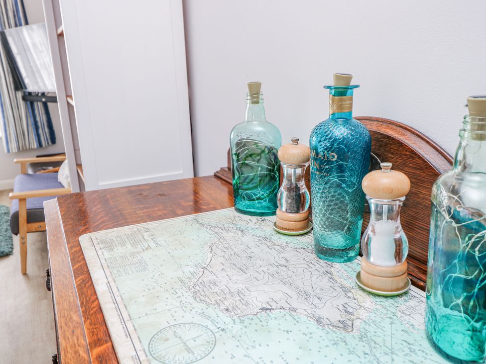 A table with bottles and shakers on a map at 2 Trelawny Way, Bembridge