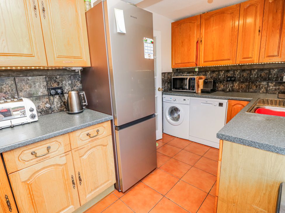 A kitchen with appliances including a fridge and washing machine at 2 Trelawny Way Bembridge