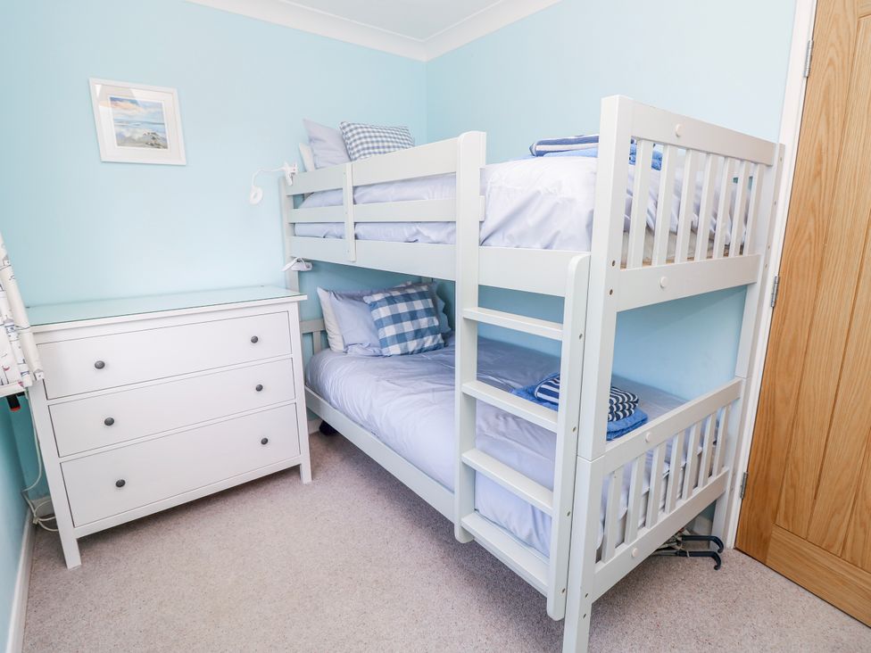 A bedroom with a bunk bed and dresser at 2 Trelawny Way in Bembridge