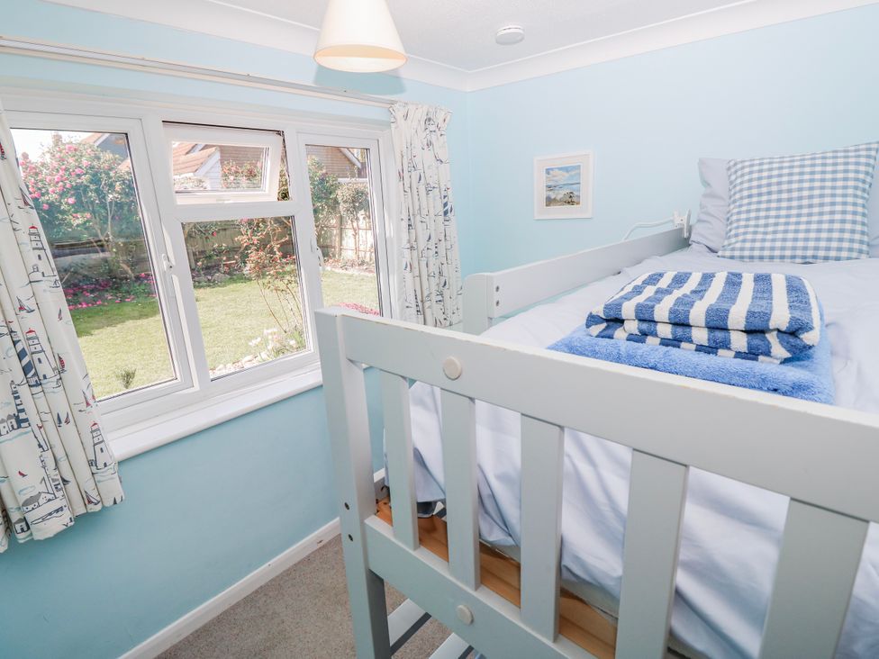 A bedroom with a bed and window at 2 Trelawny Way in Bembridge