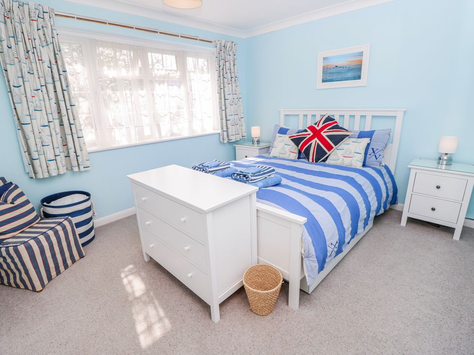 A bedroom with a bed and storage unit at 2 Trelawny Way in Bembridge
