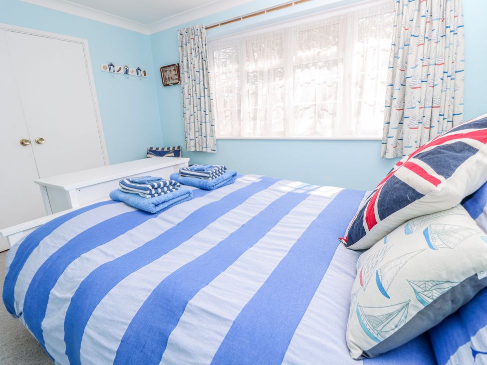 A bedroom with blue striped bedding and towels at 2 Trelawny Way Bembridge