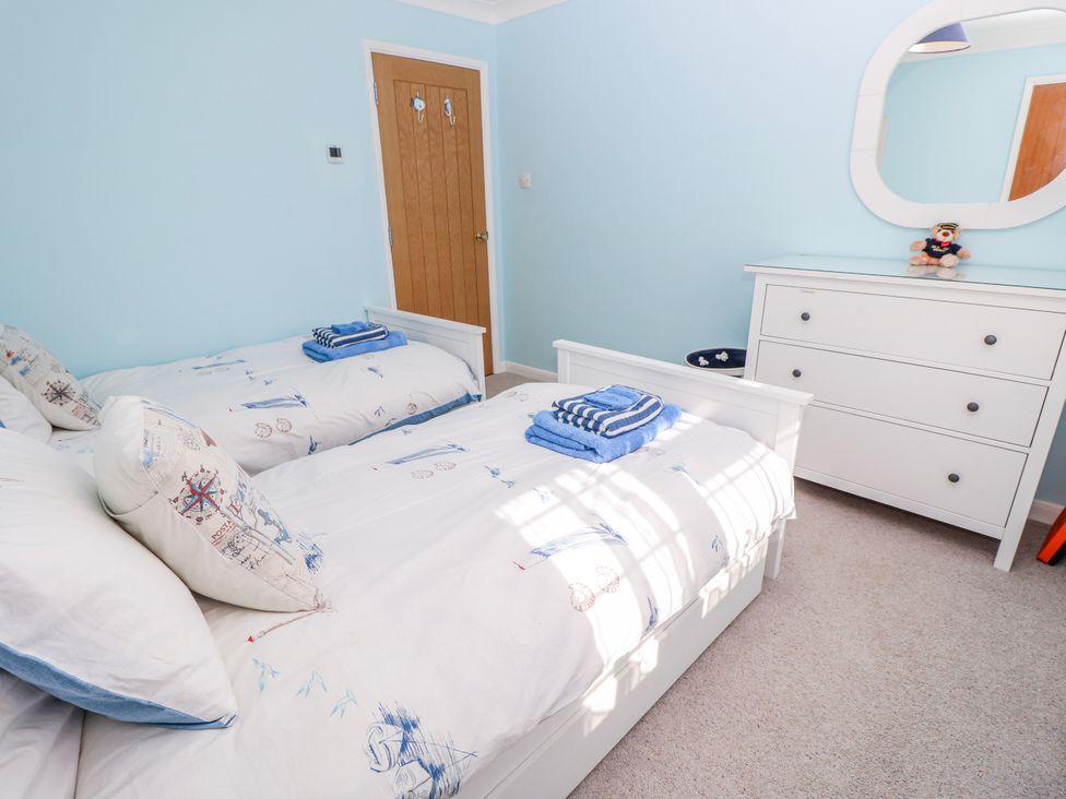 A bedroom with twin beds and a dresser at 2 Trelawny Way in Bembridge