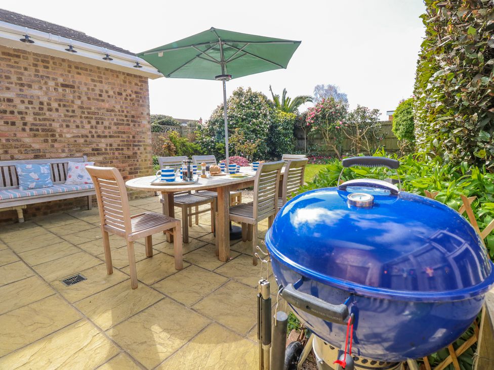 A garden with a table and chairs at 2 Trelawny Way in Bembridge