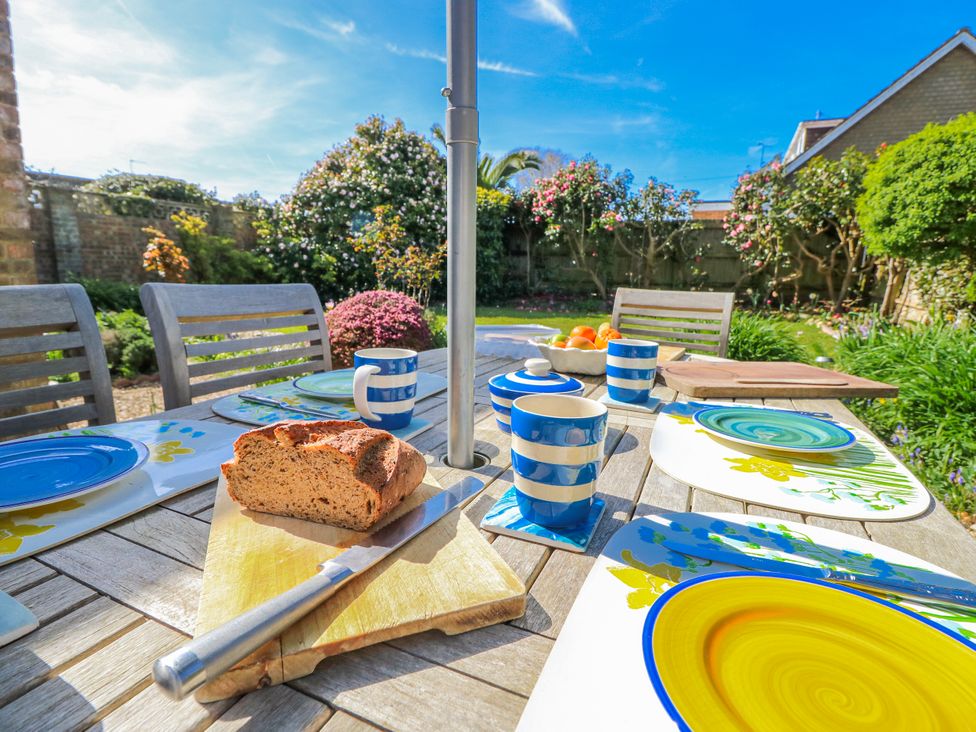 An outdoor dining area with plates and bread at 2 Trelawny Way Bembridge