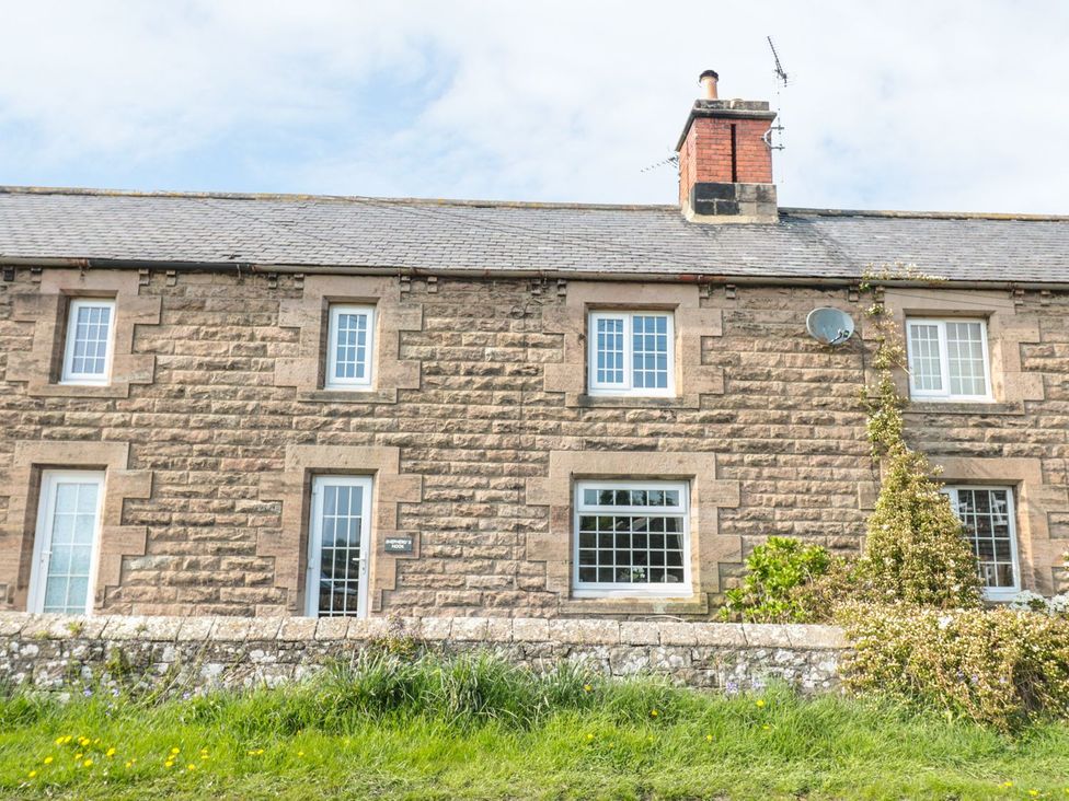 A stone house with windows and a door at Shepherds Nook in Chathill