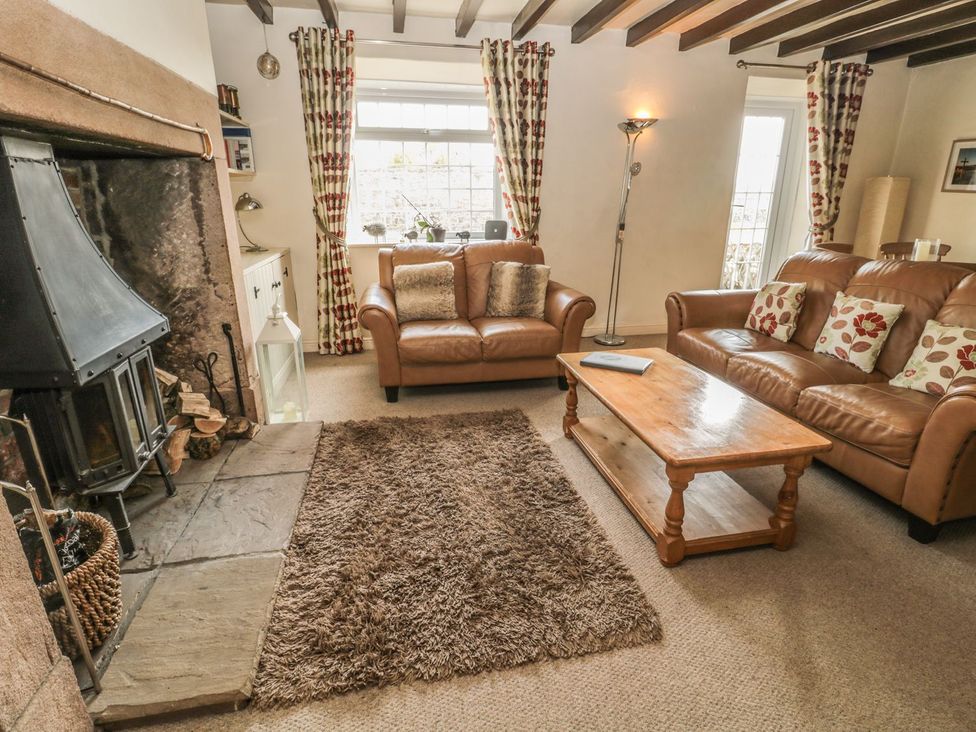A living room with a fireplace and sofas at Shepherds Nook in Chathill