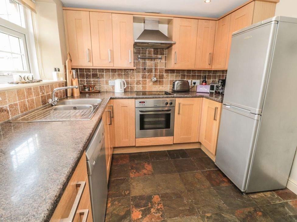 A kitchen with a sink, oven, fridge, and countertop at Shepherds Nook in Chathill