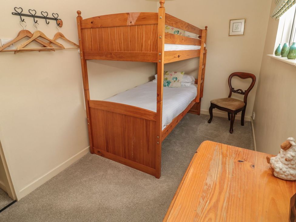 A bedroom with a bunk bed and a chair at Shepherds Nook in Chathill