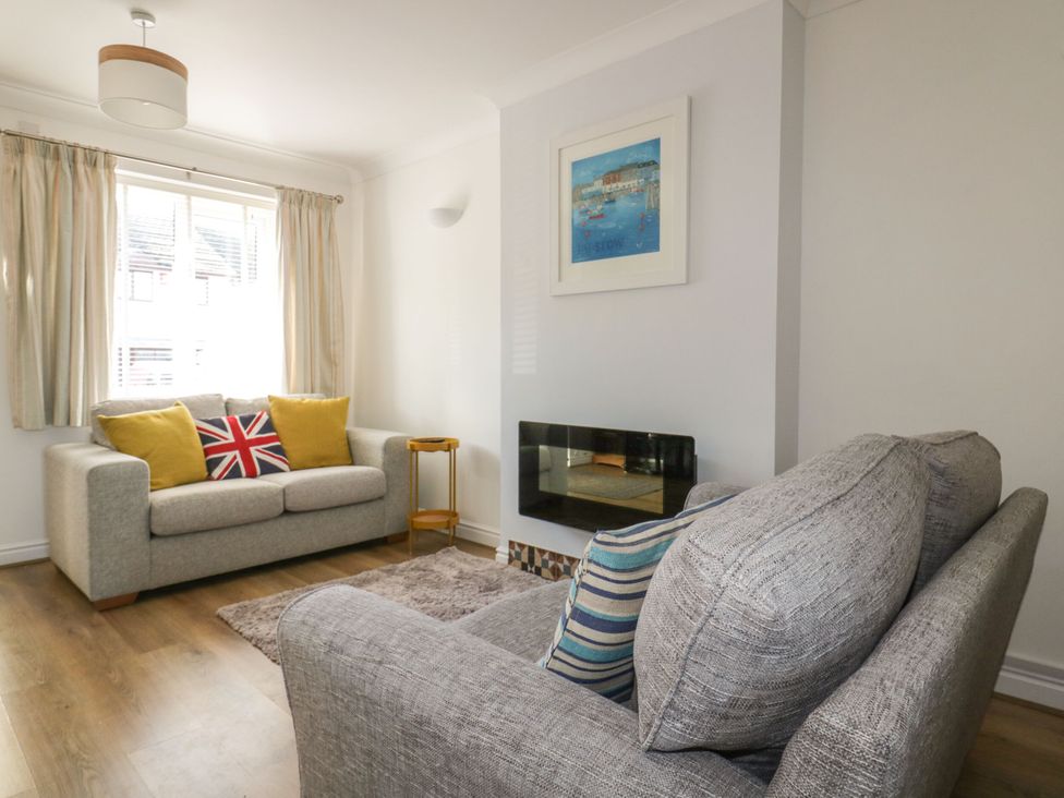 A living room with a sofa and wall art at Seahorses in Padstow