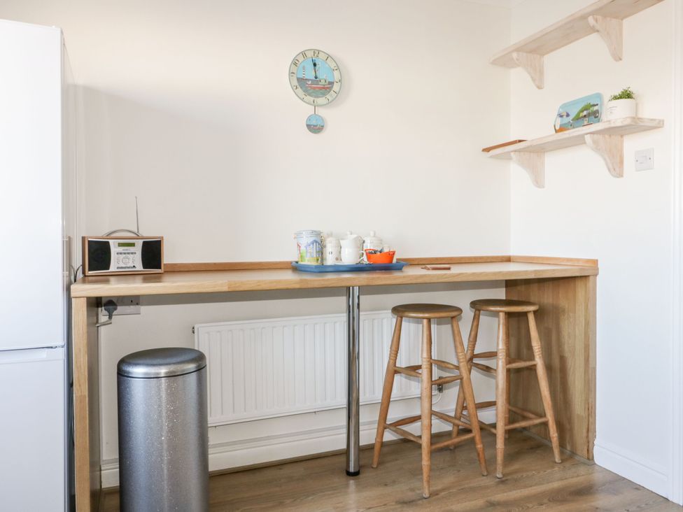 A kitchen with a bar table and stools at Seahorses in Padstow
