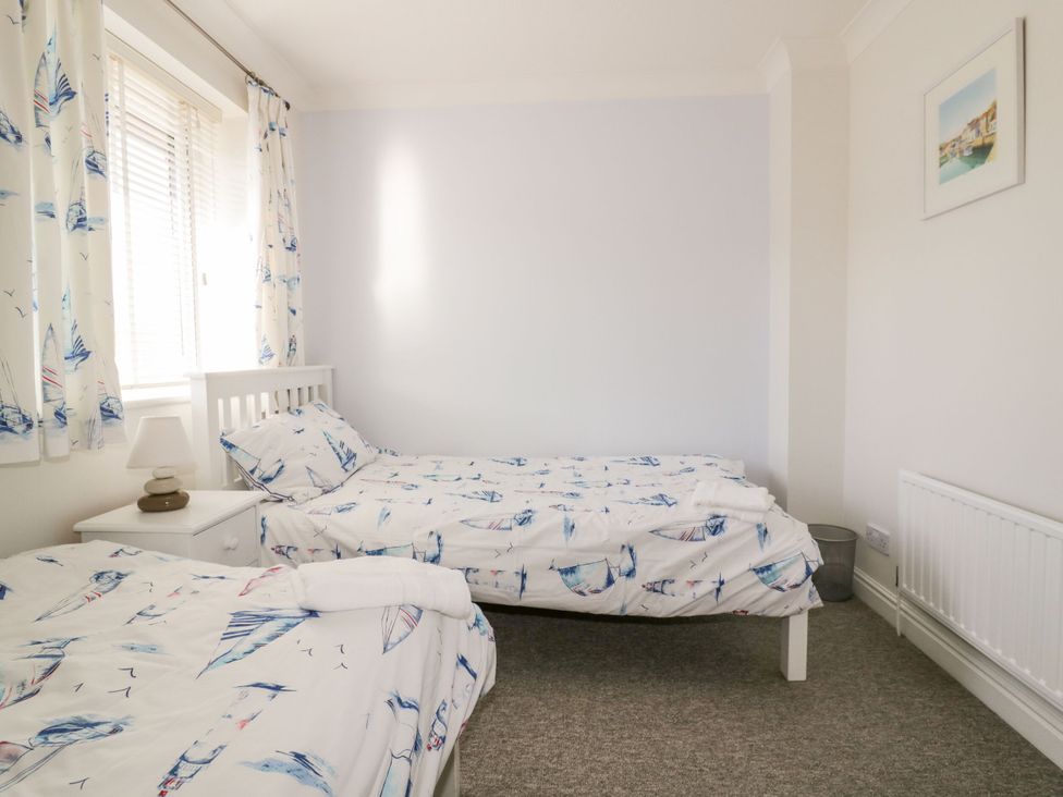 A bedroom with two beds and a bedside table at Seahorses in Padstow