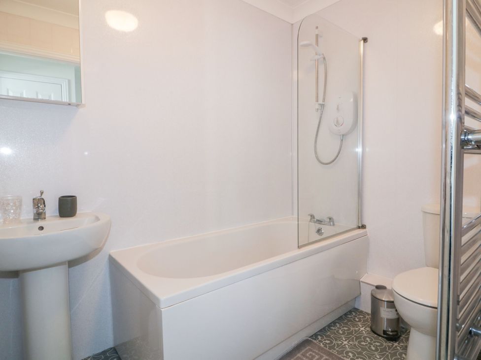 A bathroom with a bathtub, toilet, and sink at Seahorses in Padstow